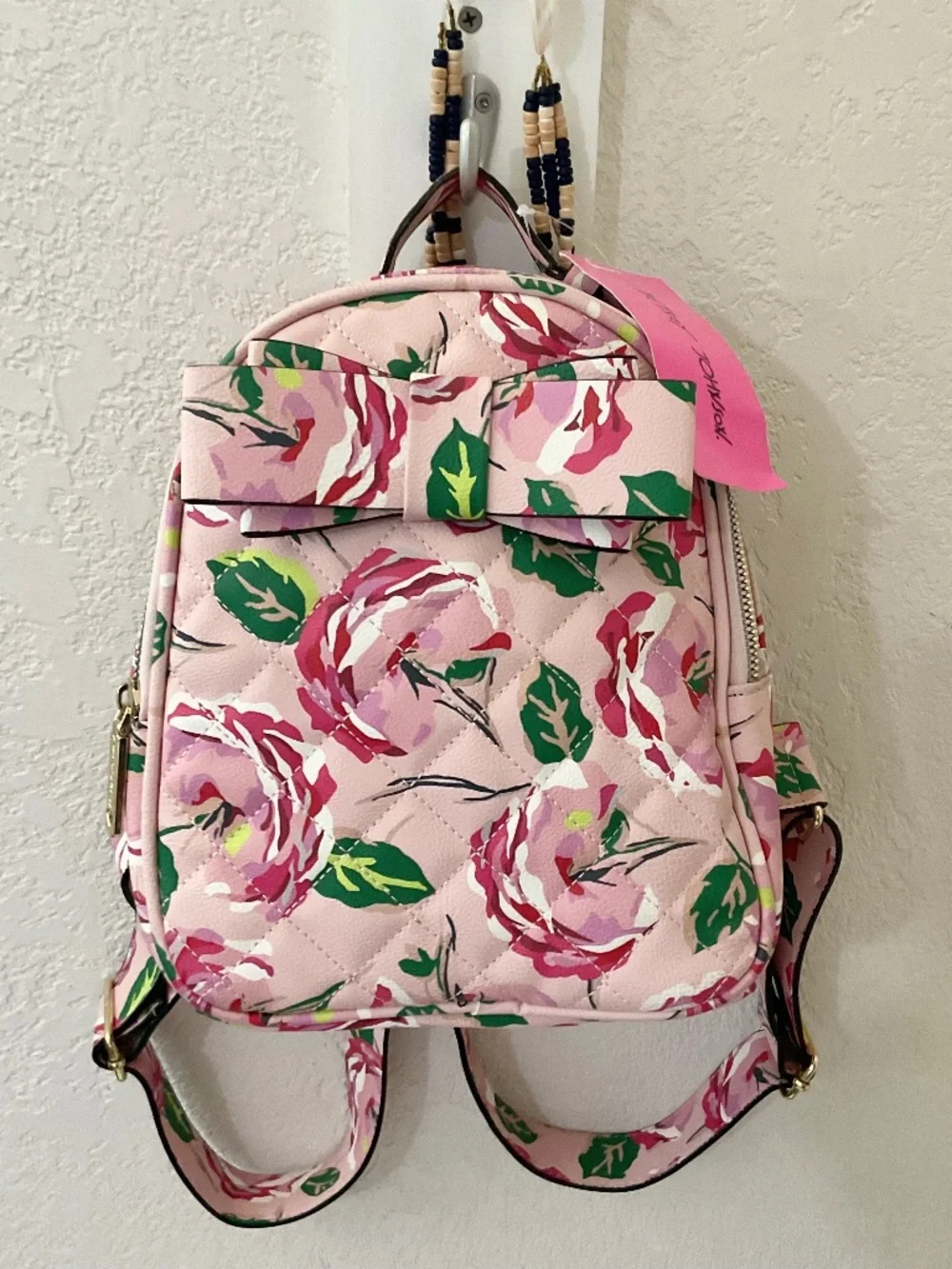 Betsey Johnson Pink Rose Quilted Mini Backpack. It features a pastel pink